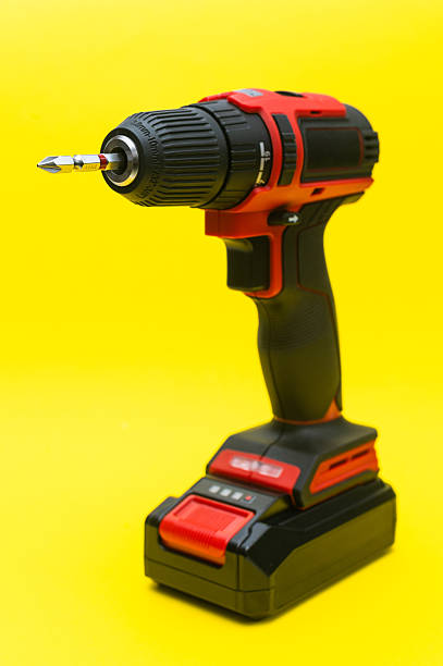 istock cordless screwdriver with a bit for self-tapping screws on a yellow background. 2188593287