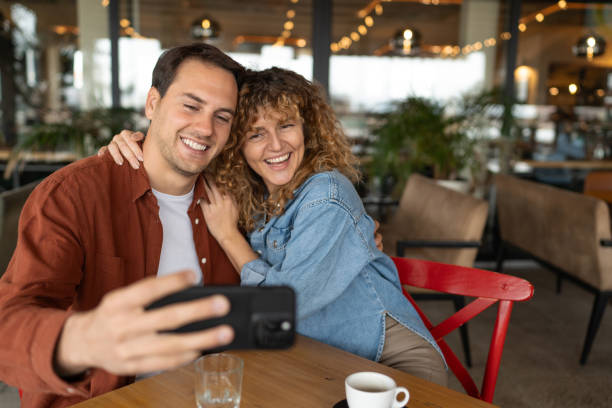 istock Happy couple having fun while taking selfie with cell phone in a cafe. 2188599329