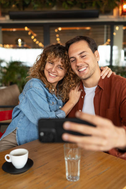 istock Happy couple having fun while taking selfie with cell phone in a cafe. 2188599722