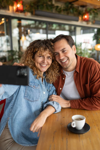 istock Happy couple having fun while taking selfie with cell phone in a cafe. 2188599776