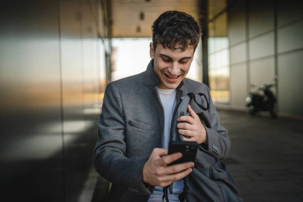 istock young man sit on bench with backpack and use mobile phone on break 2188604766
