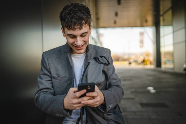 istock young man sit on bench with backpack and use mobile phone on break 2188604858