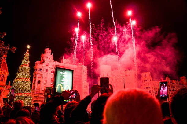 Colorful Fireworks During the Christmas Lights Switch-On Celebration with the Tree and Crowd of People Applauding and Recording