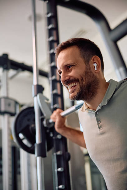 istock Happy athletic man exercising with barbell in a gym. 2188606369