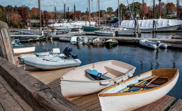 Bar Harbor, Maine USA - July 9, 2013: Waterfront in Bar Harbor, where boats are docked at the marina. Quaint shops line the streets, creating a charming atmosphere on a cloudy day.