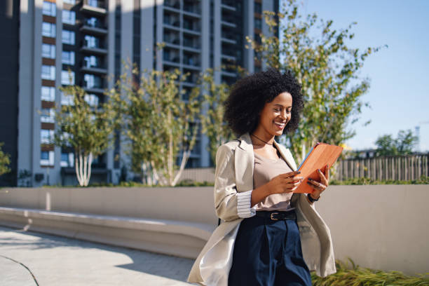 istock Businesswoman Walking Outdoors With Tablet In Urban Setting 2188609904