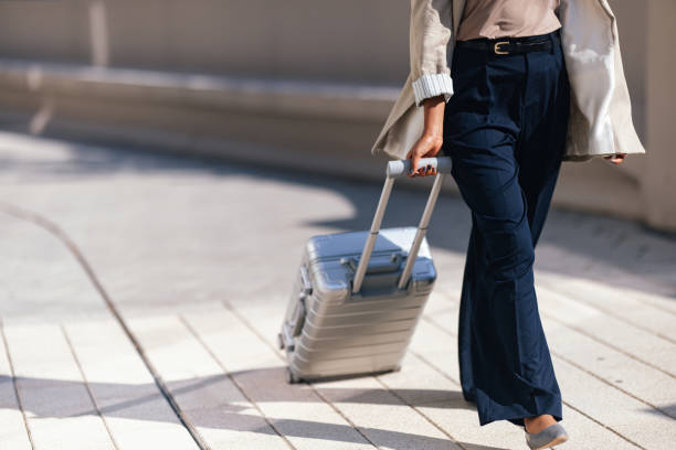 istock Woman Walking With Suitcase On Sunny Urban Pavement 2188609905