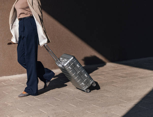 istock Business Professional Walking With Suitcase in Sunlit Urban Setting 2188609912