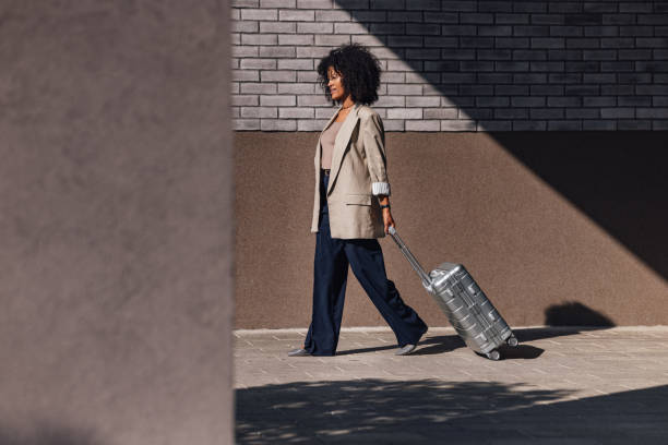 istock Confident Woman Walking With Silver Suitcase In Urban Setting 2188609919