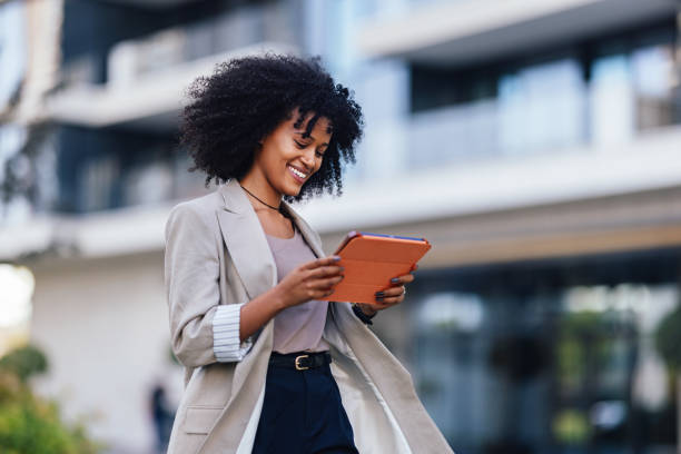 istock Smiling Businesswoman Using Digital Tablet in Urban Setting Outdoors 2188609924
