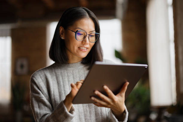 Woman in Smart Casual Attire Working on Tablet in Modern Office