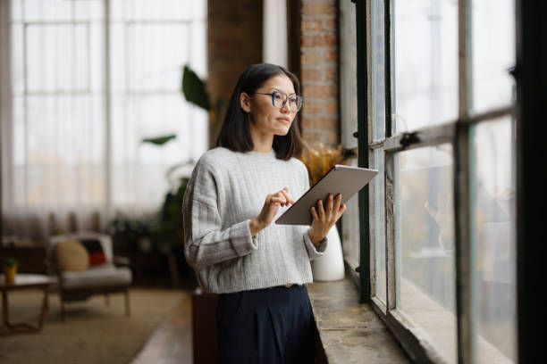 istock Woman Working On Tablet By Window In Modern Office Setting 2188611227