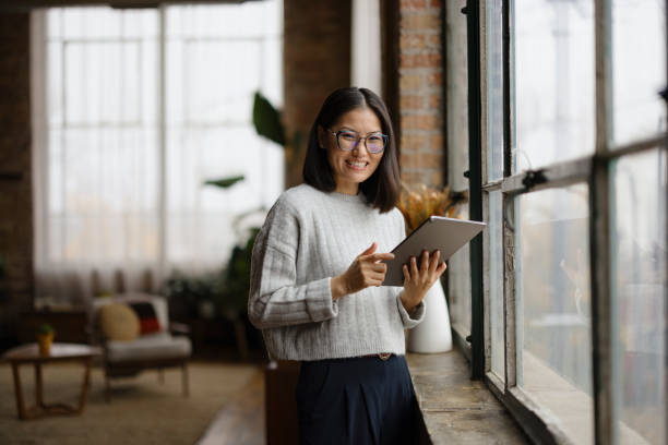 istock Smiling Woman Using Tablet in Modern Urban Office Environment 2188611233