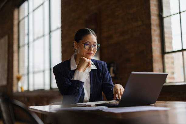 Professional Woman Working On Laptop In Stylish Office Setting