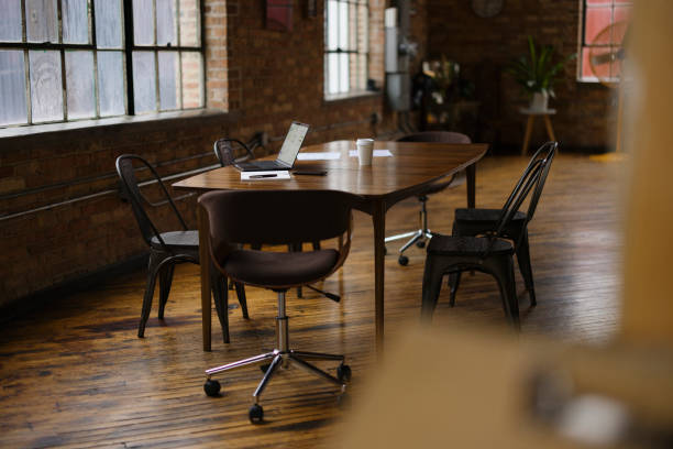 istock Modern Office Interior With Laptop on Wood Table and Industrial Chairs 2188611310