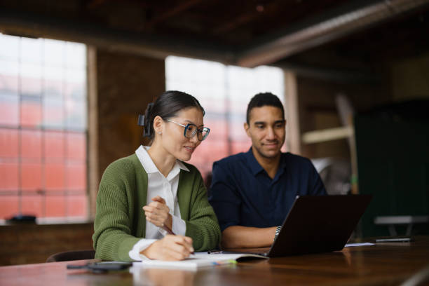 istock Colleagues Collaborating in Modern Office with Laptop and Notes 2188611311