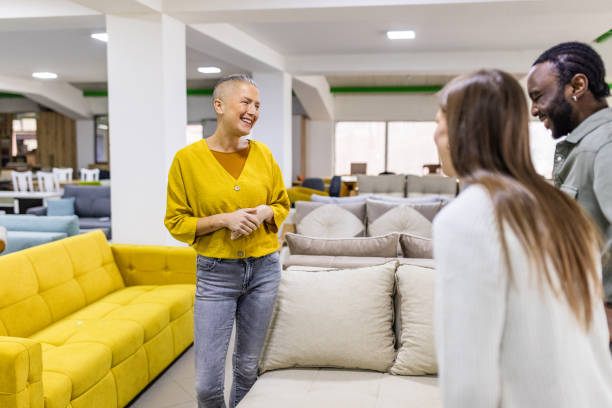 istock Salesperson showing yellow sofa to two customers. 2188617642