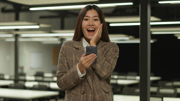 istock A woman holds her hand to her face while looking at her phone 2188626278