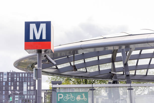 A bustling train station prominently displaying arrival times, a large clock, and enjoying beautiful sunny weather Hannover