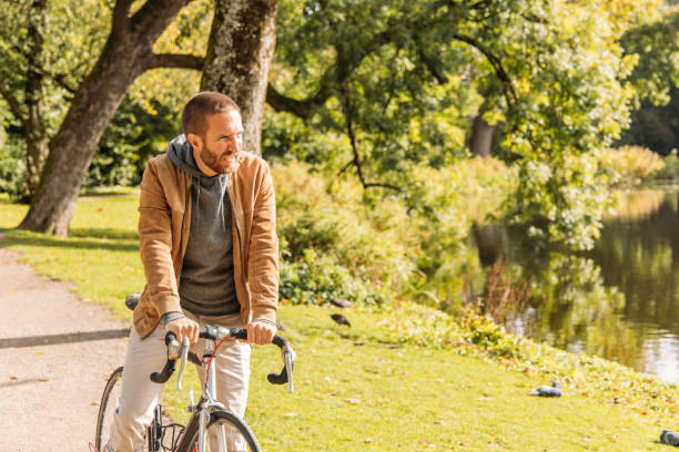 istock Man Riding Bicycle Along Scenic Lakeside Path on a Sunny Day 2188633672
