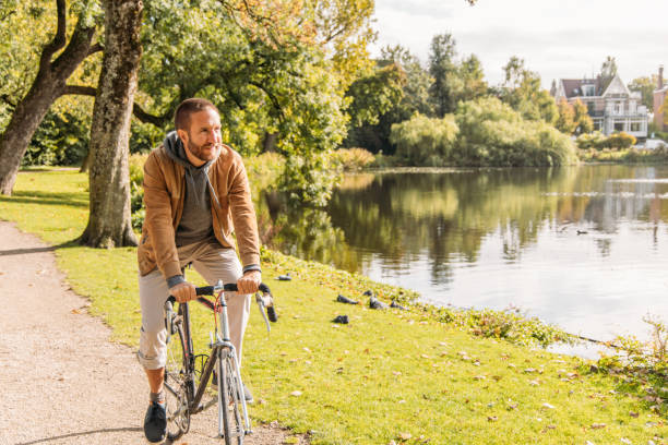 istock Man Riding Bicycle Along Scenic Lakeside in Amsterdam 2188633673