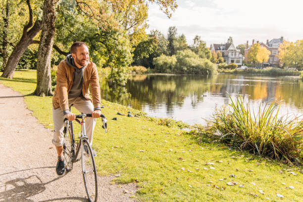Man Riding Bicycle Along Scenic Lakeside Path on a Sunny Day