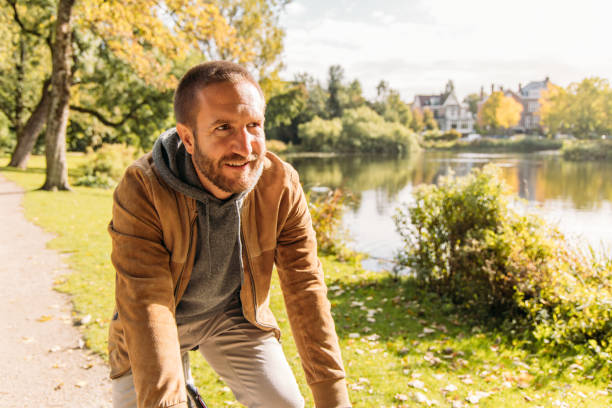istock Man Riding Bicycle Along Scenic Lakeside Path on a Sunny Day 2188633695