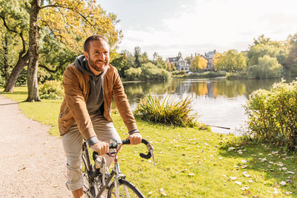 istock Man Riding Bicycle Along Scenic Lakeside Path on a Sunny Day 2188633711