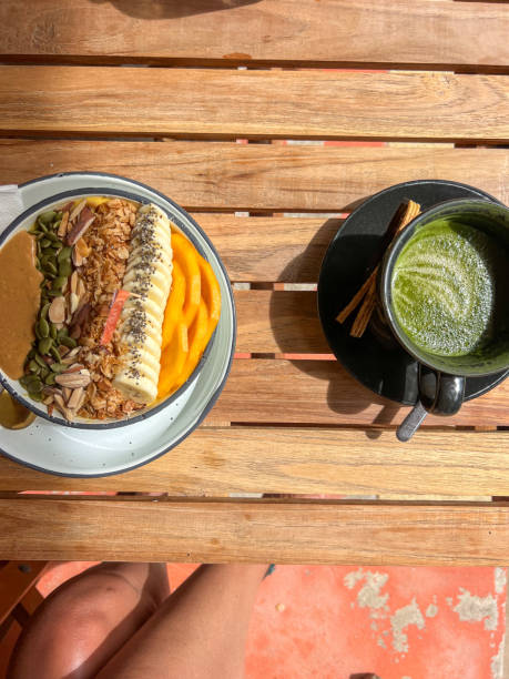 Wooden table with smoothie bowl and matcha tea