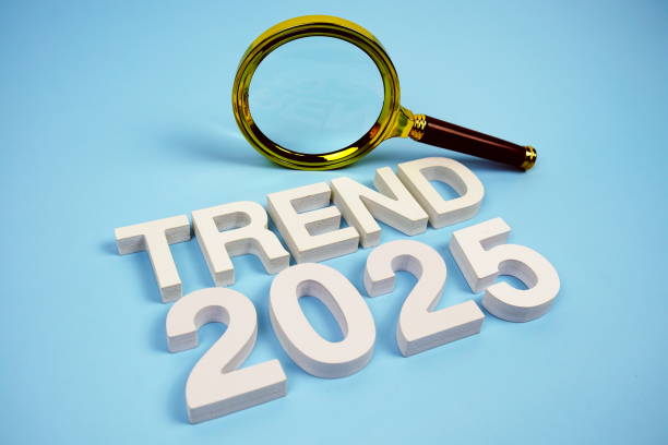 istock Trend 2025 word with magnifying glass top view on blue background 2188641359