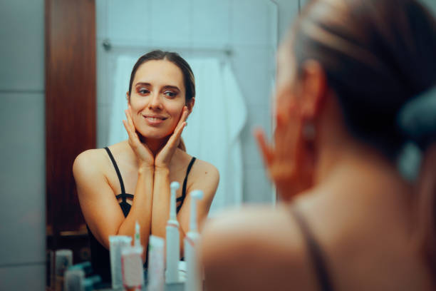 istock Happy Woman Checking her Face in the Mirror Feeling Confident 2188644425