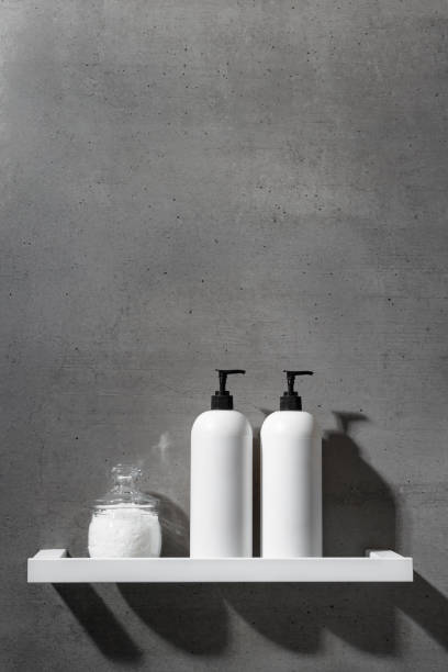istock White bottles with shampoo, conditioner and bath salt on white shelf on gray concrete background. Aesthetic view beauty products in modern minimal bathroom neutral color. Side view, copy space 2188649261