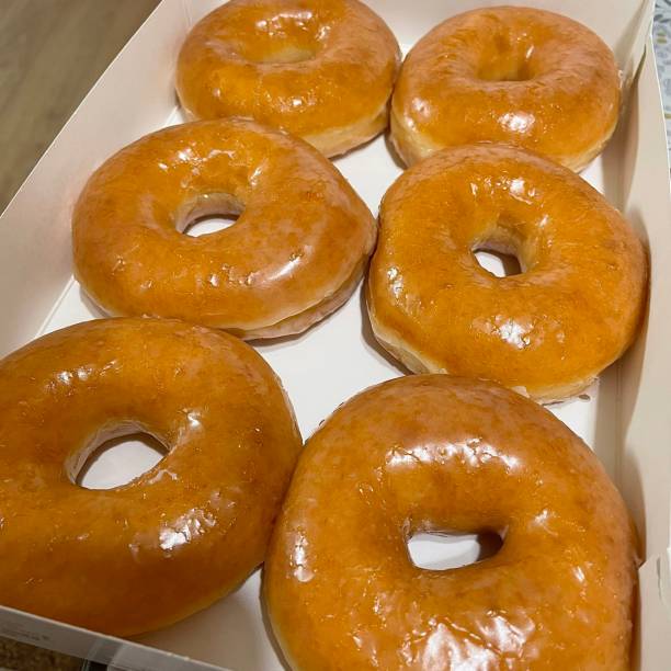 istock A classic glazed donut with a soft, fluffy texture and a sweet, glossy coating. Perfectly balanced between light and sugary, making it an irresistible treat for any time of the day. 2188650271
