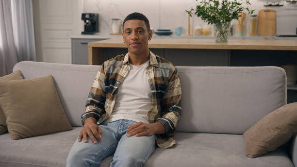 istock Portrait home glad good mood positive ethnicity man smiling looking at camera resting weekend at comfortable couch healthy African American ethnic guy male boyfriend smile toothy at sofa relax renter 2188650410