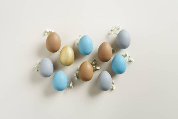 istock Easter Aesthetic with Matte Eggs and Delicate Florals, painted chicken egg decorated white flowers, top view on beige background, spring holiday concept. Minimal style pattern in pastel tones 2188652065