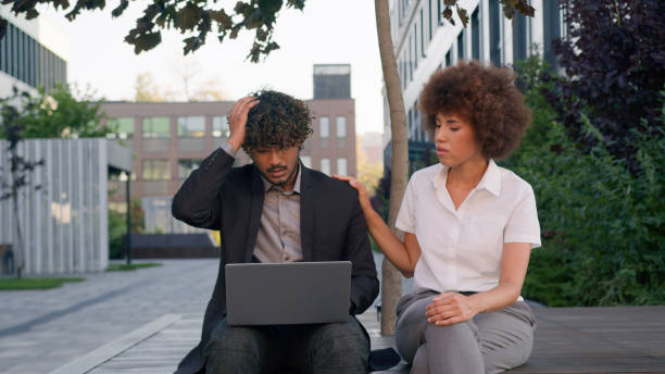Business diverse multiracial partners in city outdoor company office sad upset Indian man Arabian businessman talk failure lost problem with laptop African American woman businesswoman support calming. High quality 4k footage negocios diversos socios multirraciales en la ciudad al aire libre oficina de la empresa triste molesto hombre indio hombre de negocios árabe hablar fracaso perdido problema con la computadora portátil mujer afroamericana mujer de negocios apoyo calmante