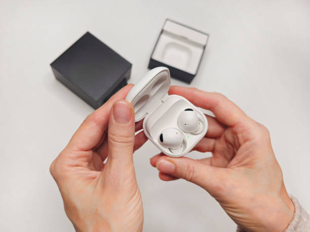istock White wireless headphones in a woman's hand, close-up. 2188653093