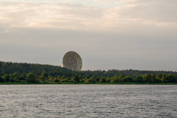 A huge satellite dish above the forest on the river bank. Radio telescope in Kalyazin radio astronomy observatory. Russia.
