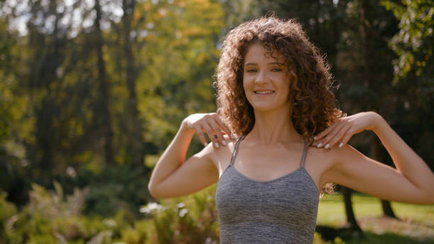 Healthy sportswoman twist spin hands circle make circular movements with shoulders workout in park outdoors sport girl Caucasian woman athlete doing exercise training warm up fit arms sporty fitness. High quality 4k footage