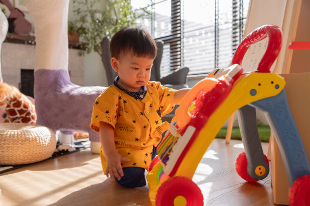 istock happiness asian baby boy focus concentrate playing by himself with colorful plastic multifunction toy he is try to touch and learn how to make a sound from this toy in living room home interior background 2188657254