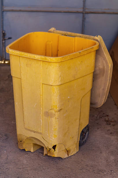 istock Old worn-out plastic container for collection of household garbage orange, red with an open lid, unfilled, possibly empty. Numerous cracks, holes in case, wear and tear of materials, tools, equipment 2188657520
