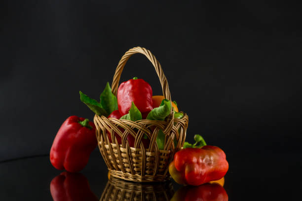 ripe red and yellow sweet peppers. Isolated on black background