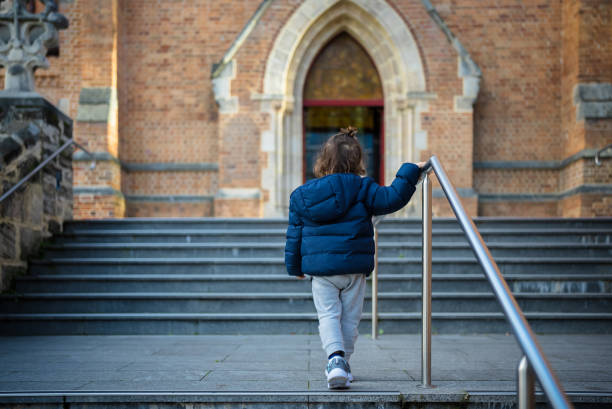 Young boy climbing steps to a building