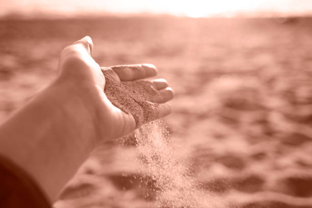 istock Close-up hand releasing dropping sand. Sand flowing through the hands. 2188663975