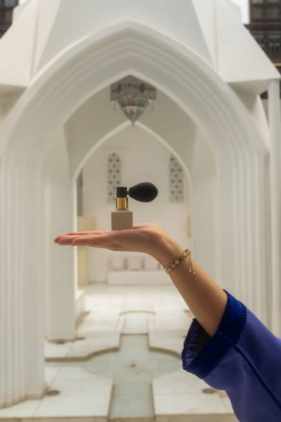 Woman presenting a perfume bottle in a mosque courtyard
