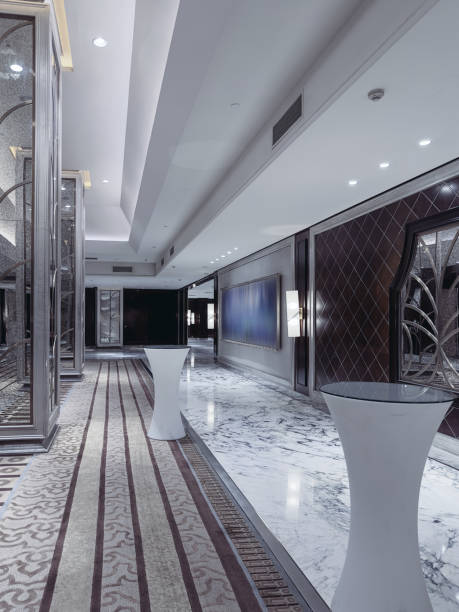 istock A modern and elegant hotel lobby or event corridor featuring luxurious marble flooring, decorative mirrored panels with art deco patterns, soft ambient lighting, and minimalist cocktail tables. 2188669539