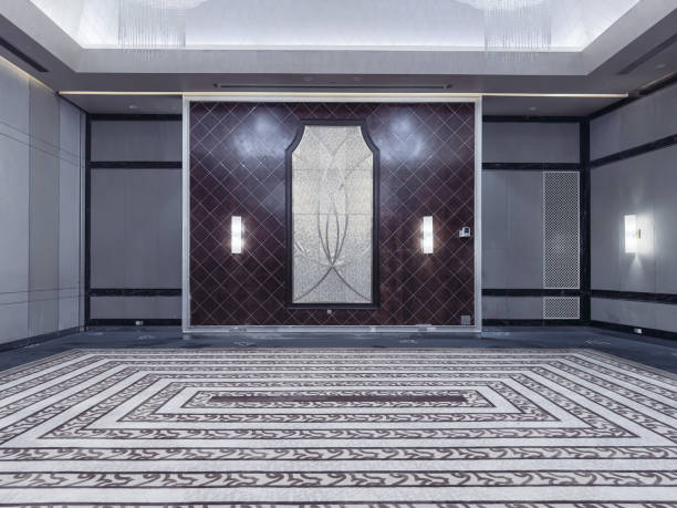 istock A modern and elegant hotel lobby or event corridor featuring luxurious marble flooring, decorative mirrored panels with art deco patterns, soft ambient lighting, and minimalist cocktail tables. 2188669835