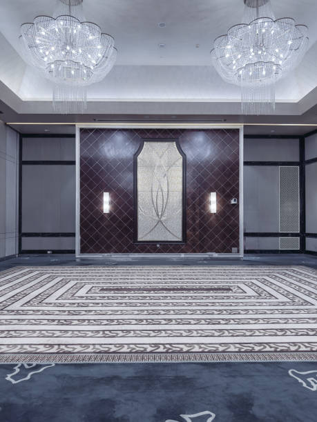 istock A modern and elegant hotel lobby or event corridor featuring luxurious marble flooring, decorative mirrored panels with art deco patterns, soft ambient lighting, and minimalist cocktail tables. 2188669838