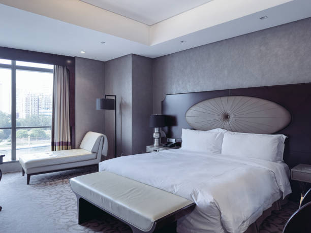 istock A luxurious and modern hotel room featuring a king-sized bed with crisp white linens, a stylish headboard, and elegant bedside lamps. 2188669951