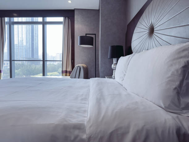 istock A luxurious and modern hotel room featuring a king-sized bed with crisp white linens, a stylish headboard, and elegant bedside lamps. 2188669979